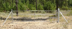 Barbed wire with a large galvanized 4 rail gate