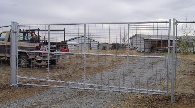 Large gate entry with filed fence on sides of gate.