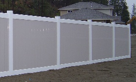 White vinyl frame with pebblestone pickets by valley fence